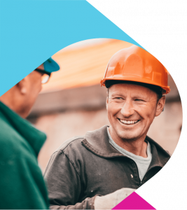 Man in orange hard hat smiling and talking to a colleague