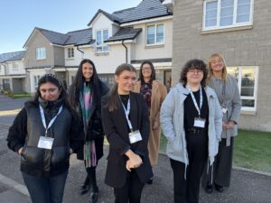 A group of people stood in front of new houses.